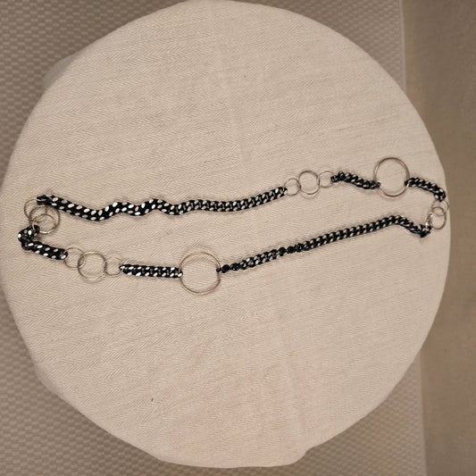 Halskette „Chain Reaction“ mit silberfarbenen Gliedern und schwarzem Stoffband mit weißen Punkten – auffälliger, flexibler Materialmix